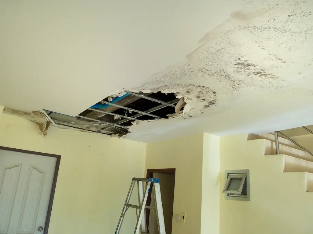 water damaged ceiling in a yellow room