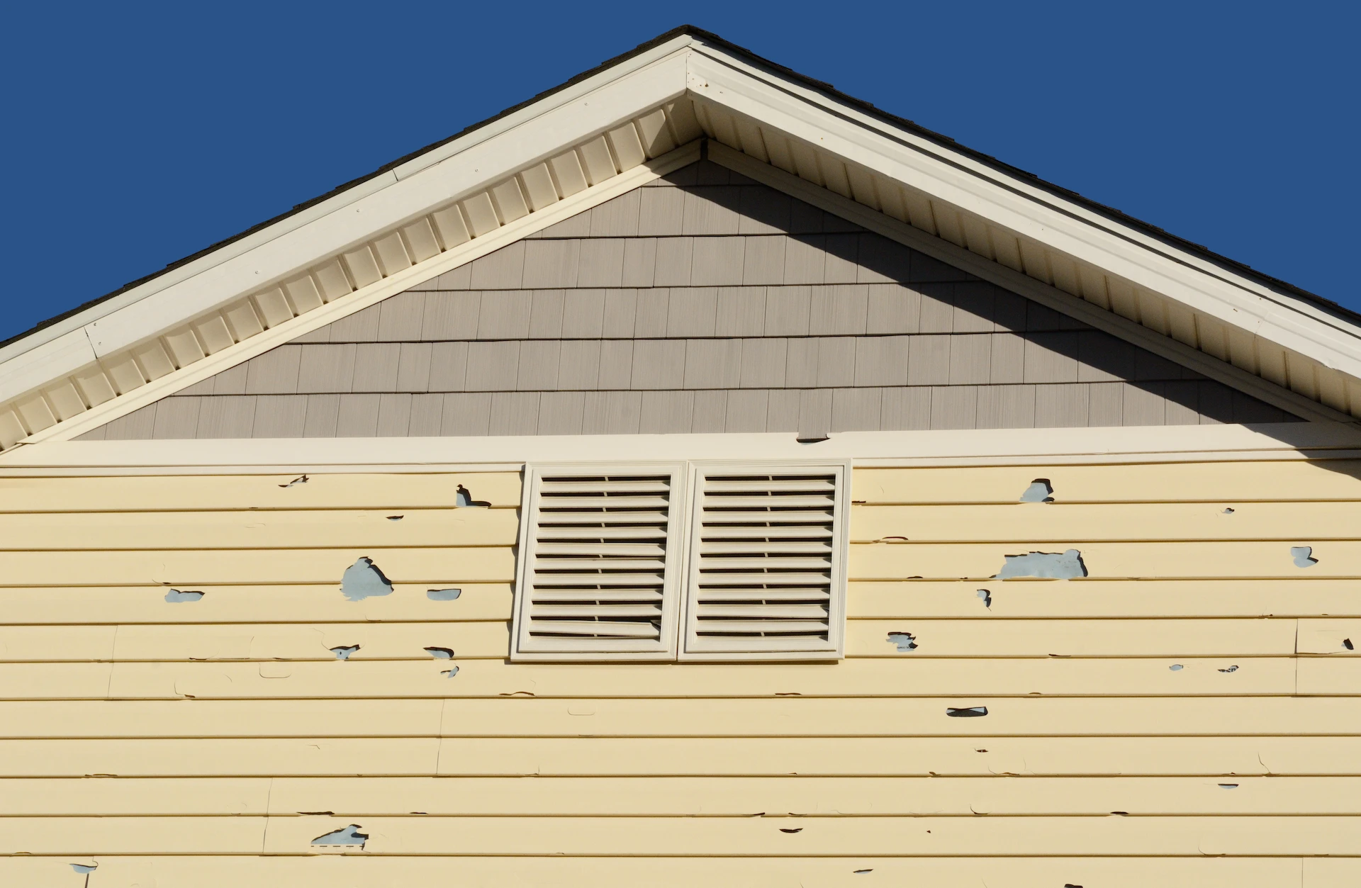 siding of house has peeling paint