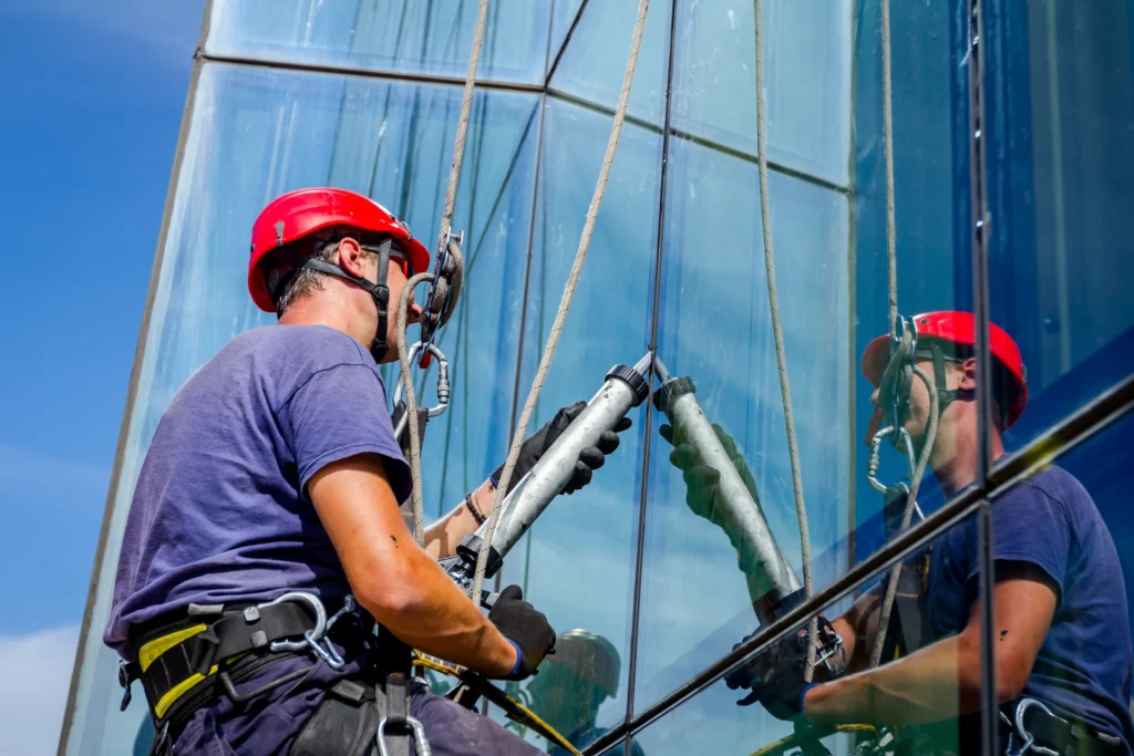 worker using a sealant on a window