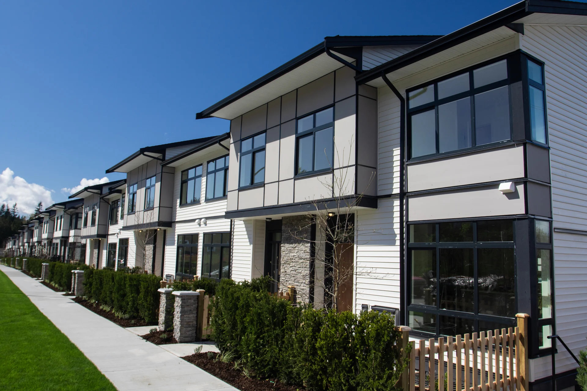 Residential townhouses on blue sky background on sunny day. External facade of a row of colorful modern urban townhouses.brand new houses just after construction on real estate market